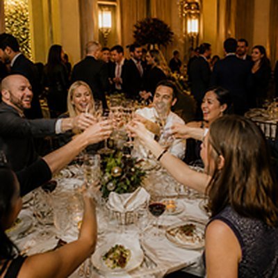 Company holiday party guests toasting in a ballroom venue